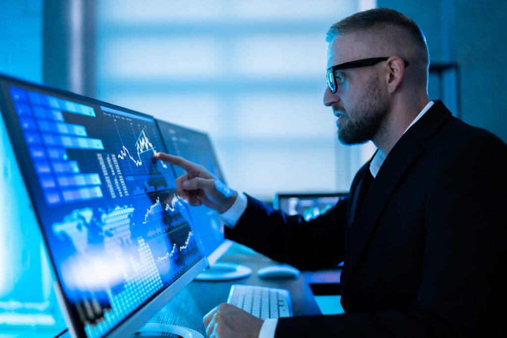 Analista revisando gráficos, mapas y datos predictivos en un monitor de visualización avanzada.